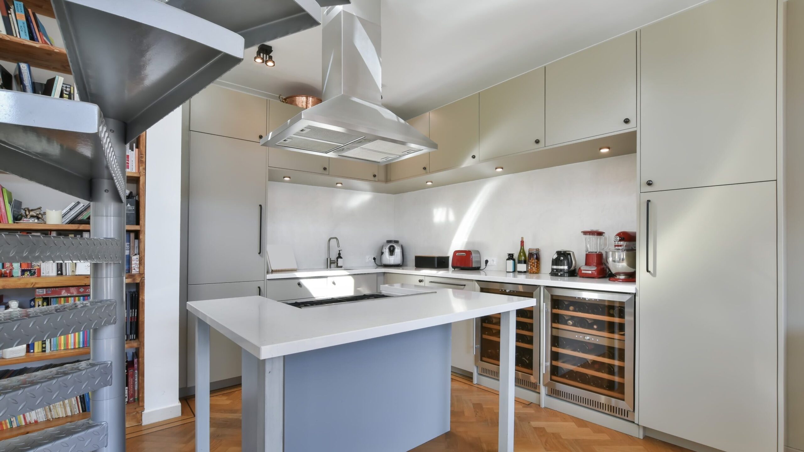 salas tipa tvaika nosūcējs bēšas virtuves vidū